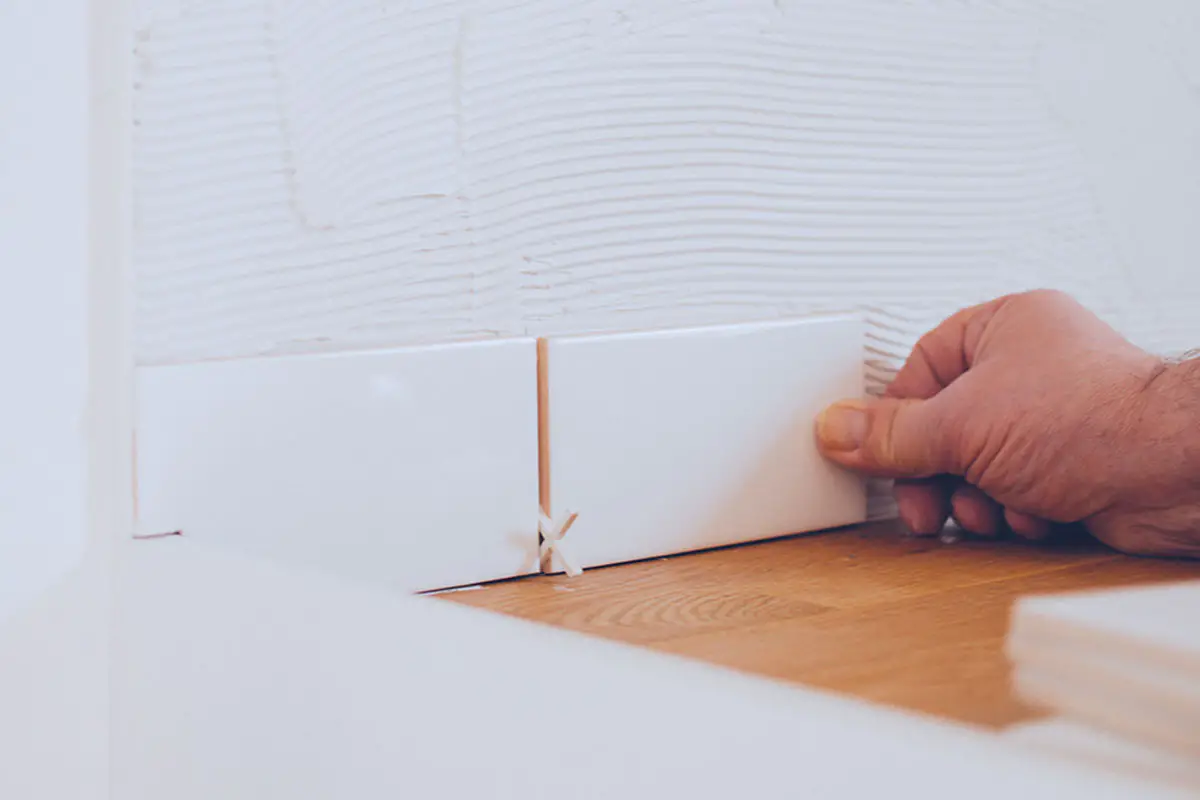 Man putting subway tile on wall